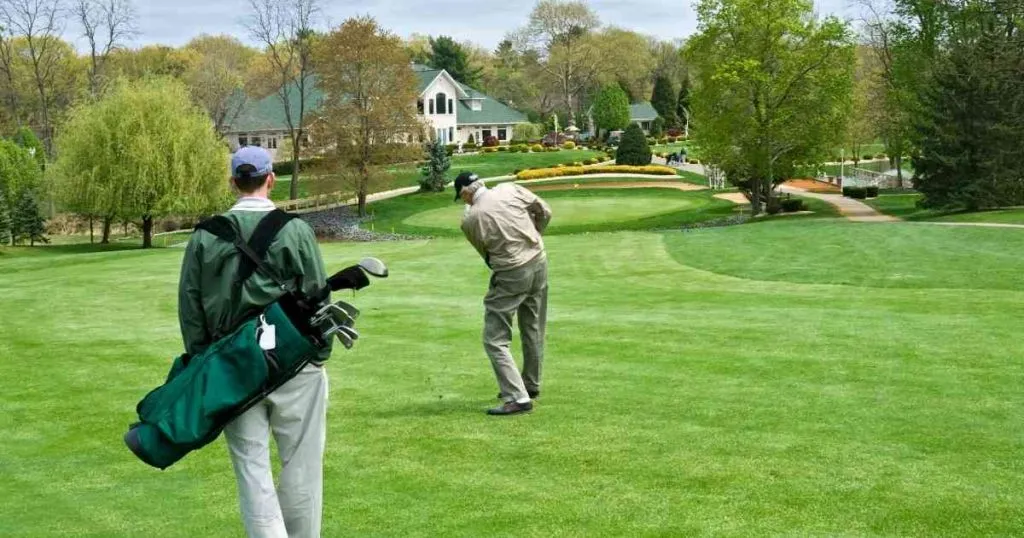 man playing golf with caddie